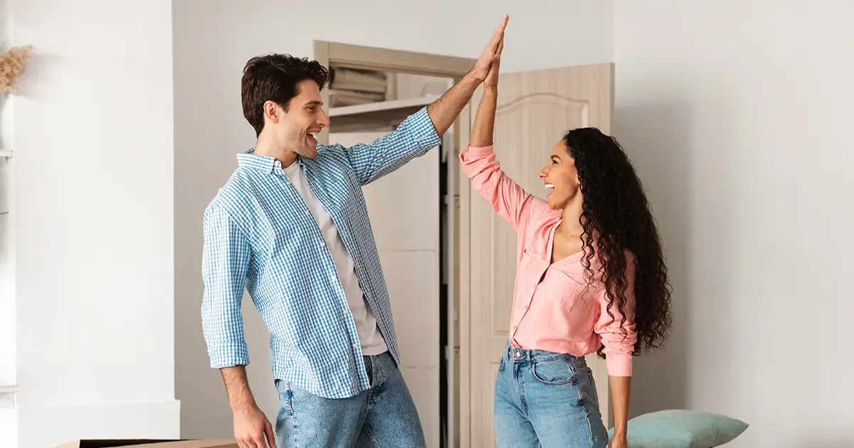Happy couple celebrating move-in day with high-five.