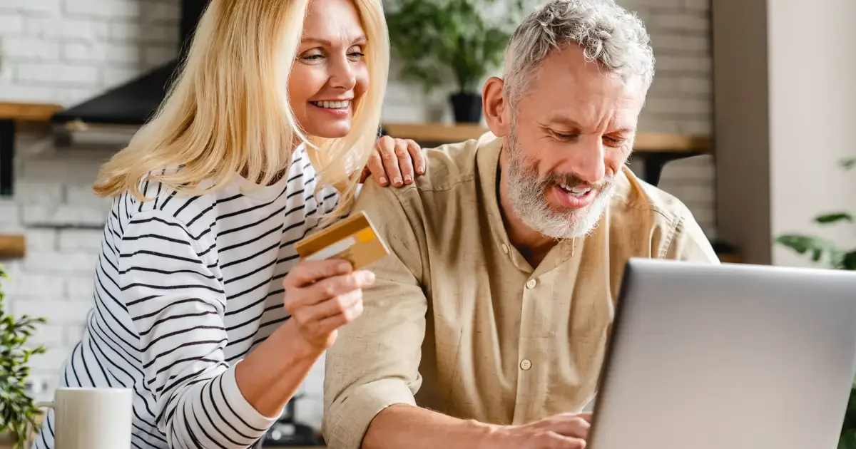 Older couple with credit card and laptop